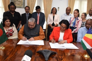 Minister Telemaque and Minister Ahmad sign the agreement